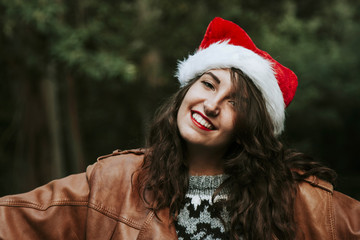 attractive young woman smiling with christmas hat outdoors