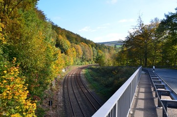Straßenverkehrssysteme in Herbstlandschaft - Bahnschienen - Bahngleise - Straße - Brücke - Leitplanken  