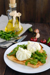 Boiled eggs in a pouch (poached) on crispy toast and green arugula leaves. Dietary breakfast.