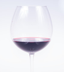 glass of red wine in the foreground on white background, isolated subject