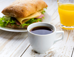 Chiabatta sandwich, cup of coffee and orange juice