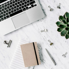 Flat lay, top view office table desk. Workspace with laptop, diary, succulent and clips on marble background.