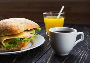 Chiabatta sandwich, cup of coffee and orange juice