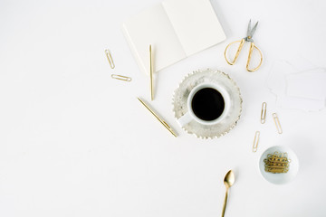 coffee cup, empty diary and golden accessories: tea spoon, pen, clips and scissors on white...