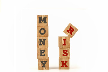 Money and Risk message written on cube shape wooden surface isolated on white background.