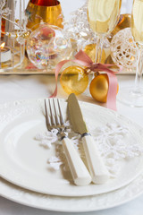 Tableware set for christmas - set of plates, cups and utencils close up with golden chrismas decorations