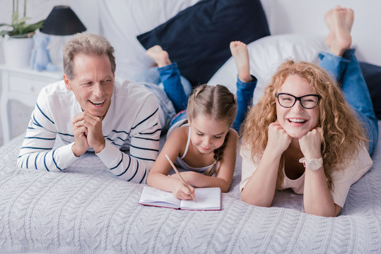 Cute girl drawing and having fun with her grandparents