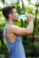 Young athlete drinking water in park