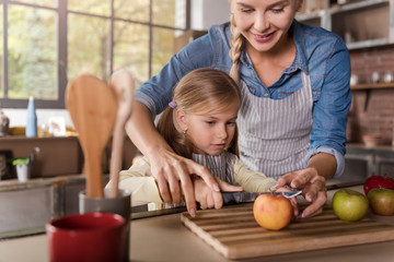 Cute girl cooking with her mother in the kitchen