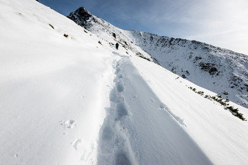 tourists enjoying high mountains in snow on a sunny day