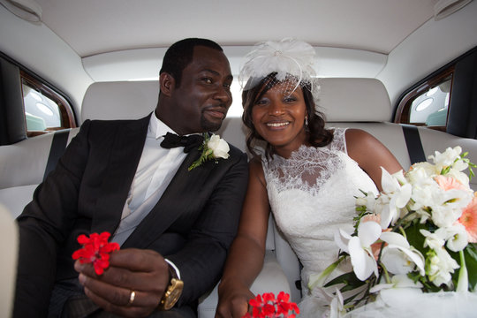 Happy newlyweds of beautiful bride woman in car for wedding black couple
