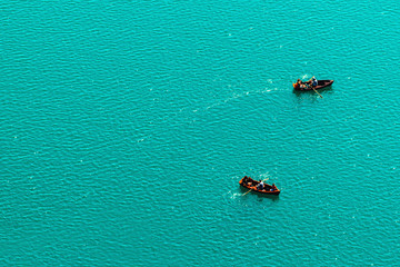 People rowing in boats on lake, enjoying summer