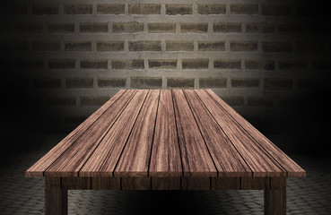 wooden table in front of brick wall 