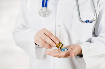 Doctor pouring pills on his hand. Medical concept in hospital.