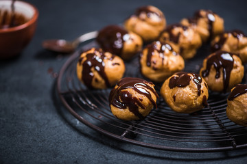 profiteroles eclairs resting on cooling rack