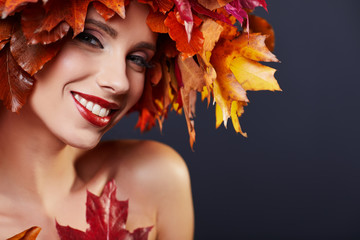 Fototapeta premium Woman with leafs on head in autumn concept.