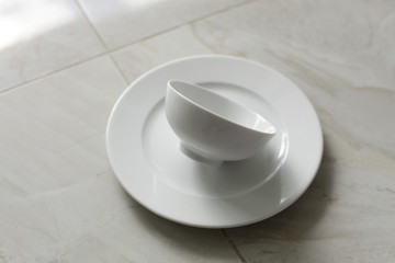 empty bowls, plates and cups on gray background