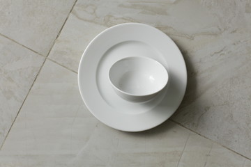 empty bowls, plates and cups on gray background