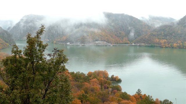 Autumn at the Danube Gorges, the border between Romania and Serbia. View from Serbian part. In the background, on the Romanian bank, the Decebal king's image carved in stone and monastery Mraconia. 4K