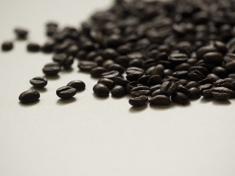 Verstreute Kaffeebohnen auf einem wei&szlig;en Tisch