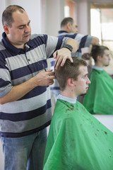 Man trimming customer hair at salon
