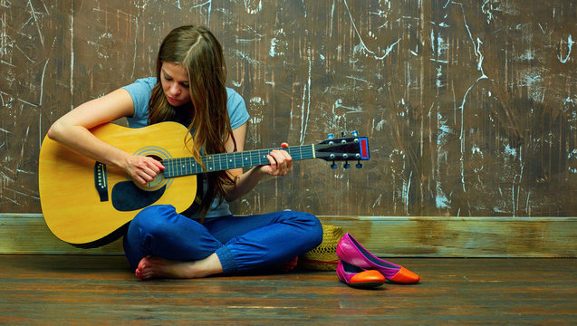 Portrait of young woman with guitar.