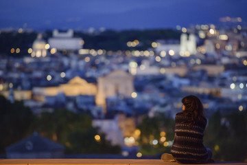 Girl thinking over the city, back view in Rome, Italy.