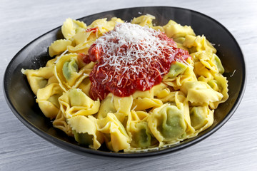 Traditional Italian homemade spinach and ricotta tortellini With marinara souce  parmesan