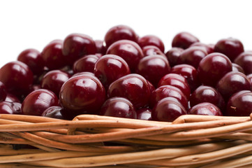 Basket full of fresh red cherry on a white background