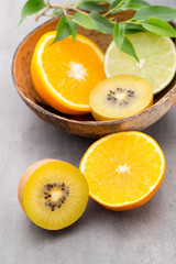 Mixed citrus fruit lemons, orange, kiwi, limes on a gray backgro