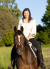 Fototapeta premium Women on Horseback Riding in a Landscape