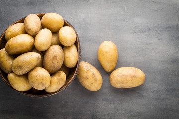 New potato on the bowl, gray background.
