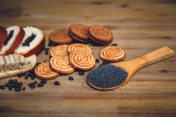 There are Pieces of  Roll with poppyseed,Cookies,Halavah,Chocolate Peas,Tasty Sweet Food on the Wooden Background