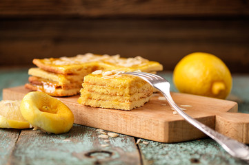 Oldfashioned imperfect layered lemon cake on wooden board