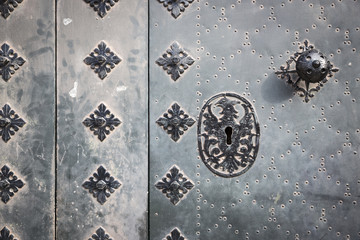 handle and lock of an ancient metallic door with metallic ornaments