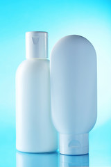 White cosmetic bottles on a blue background