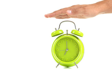 Green alarm clock with male hand on white background