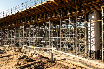 .construction scaffolding built under an overpass over the highw