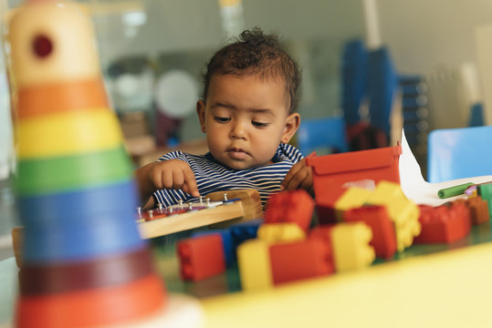 Happy baby playing with toy blocks.