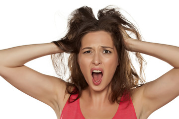 portrait of nervous young woman with itching in her hair