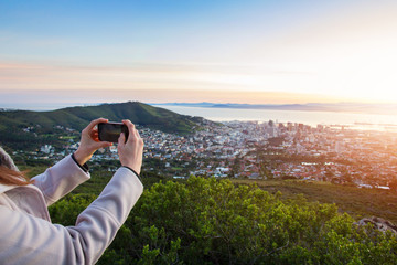 Fototapeta na wymiar Female tourist taking photo of Cape town in the background