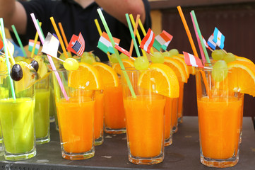 Assortment of fresh tropical cocktails with straw , fruits and flags
