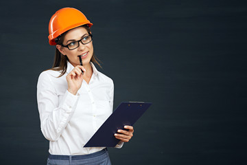 Woman builder thinking on black background.