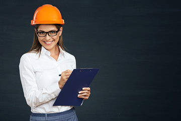 Woman architect writes on clipboard.