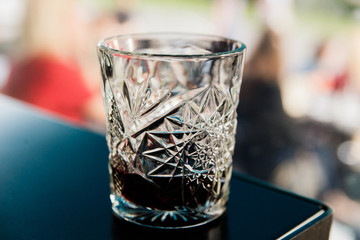 An old fashioned glass with red port wine. Bokeh background. Selective focus. Small depth of field. Underexposed image.