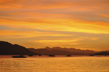 Sunset red sky on Coron city in the Philippines with a few tipic boat on the foreground