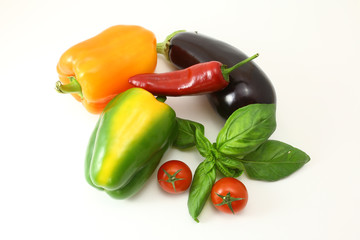 Concept of vegetarian food with tomatoes, yellow paprika, red chilli and green basil