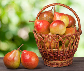 pears in a wicker basket on  wooden table with  blurred background