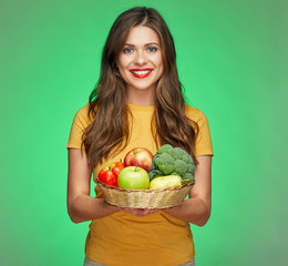 toothy smiling woman holding straw basket with healthy food