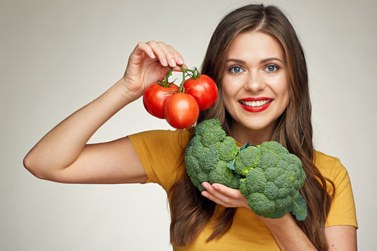 Smiling woman isolated portrait with tomato and broccoli.